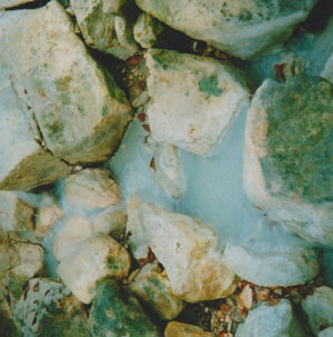 Close-up of irregularly shaped rocks partially submerged in clear water.